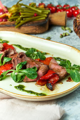 Carpaccio with sauce and spinach. Beautiful serving dishes. Light background. Restaurant menu