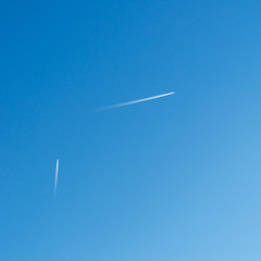 Zwei Kondensstreifen am blauen Himmel