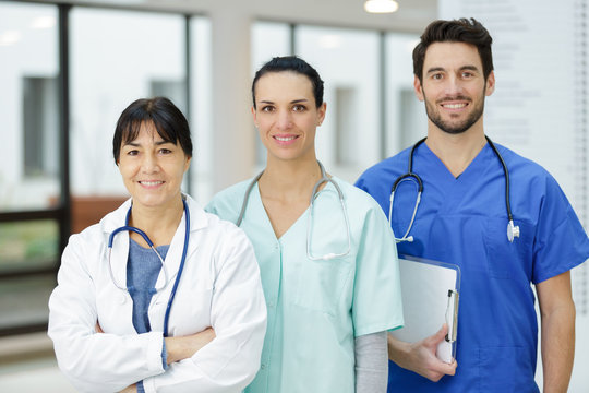 medical practitioners and young surgeons looking at camera