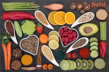 Health food selection for liver detox concept with fresh fruit, vegetables, legumes, herbal medicine, grains, seeds, supplement powders, herbs and spices. Top view on slate.