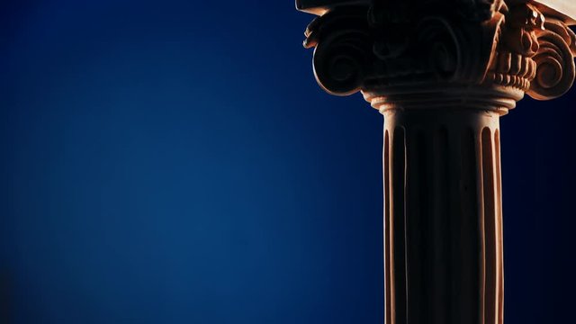 Single ancient column rotating slowly on blue background
