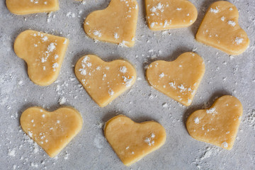 Raw dough cookies in the shape of hearts. The process of making cookies and gingerbread at home. pattern close-up