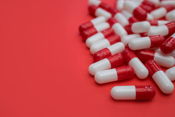 Drugs pills capsules on red color background