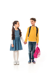 full length view of schoolchildren with backpacks holding hands isolated on white