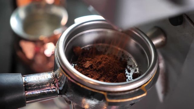 Closeup shoot of coffee beans being freshly grounded in a coffee blending machine indoors in a cafe
