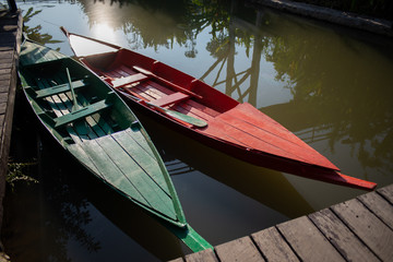 Red boat and green boat on a port waiting for people