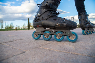 Fototapeta na wymiar Closeup of legs with roller skates in action in beautiful city park