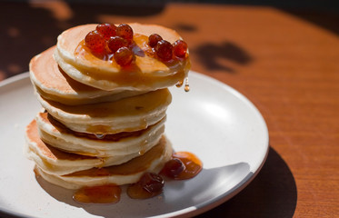 pancakes with strawberry jam. Strawberry jam. pancakes with syrup. pancakes on a plate