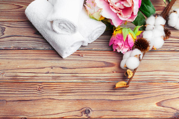 Cotton flowers with towel on wooden table