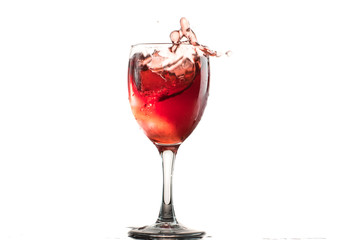 A glass of red wine on a white or black background with splashes.