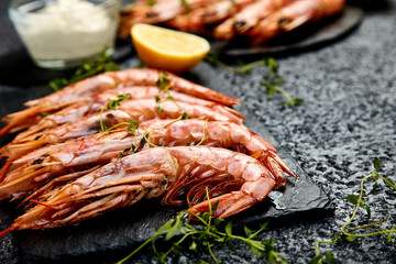 Grilled big tiger shrimps prawns on black slate plate