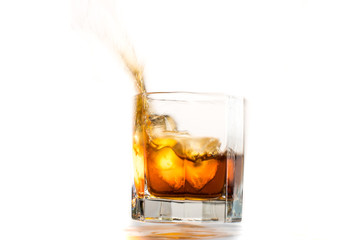 Fallen and falling whiskey glass with ice and splashes