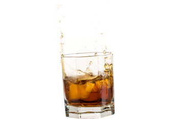 Fallen and falling whiskey glass with ice and splashes
