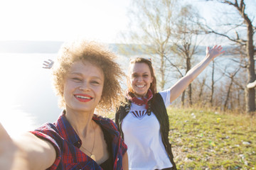 Two women hiker takes a selfie with a cell phone