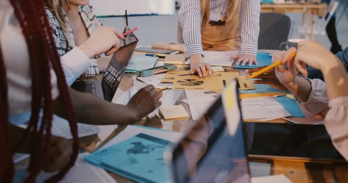 Healthy multiethnic workplace concept. Close-up happy business colleagues working together at office meeting table.