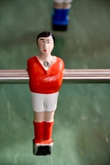 Table soccer player in red outfit.