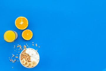 Bright breakfast with granola and orange juice on blue background top view mockup