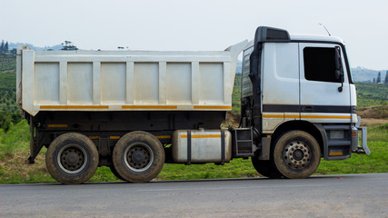 side view of a dirty white tipper truck © derren