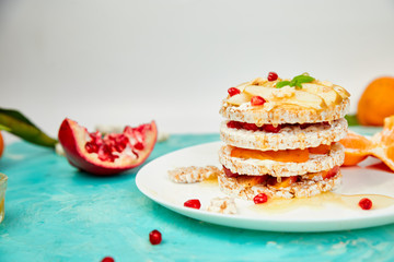 Vegan, diet, organic natural birthday cake with rice crisp bread and tropical fruits on blue background. Easy food. Healthy layered dessert. .