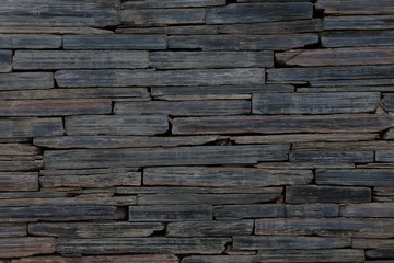 Rustic dark stone wall background for texture and design backdrop purpose	