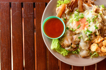 Stir-fried rice noodle with chicken, squid, fry egg and lettuce