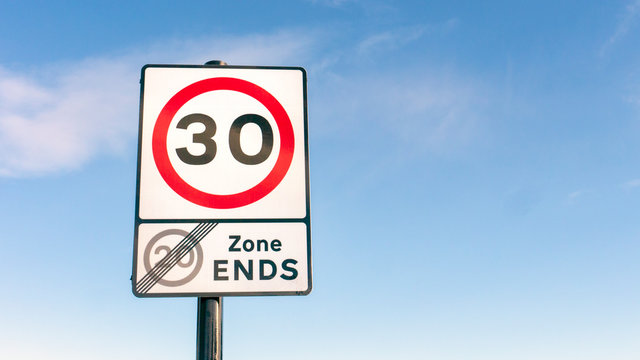 Traffic Road sign for 30mph (miles per hour) speed limit zone and end of 20 mph speed limit zone in England
