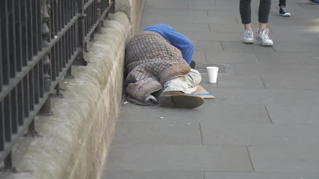 A homeless man sleeping on the street.