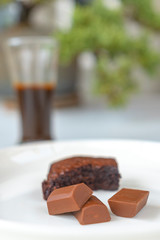 Bitten brownies and black chocolate in a white plate