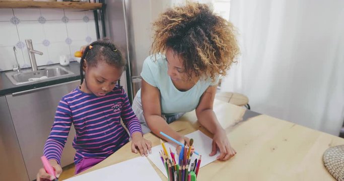 Happy black mother and daughter drawing