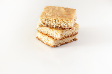 Stack of square pieces lemon cake isolated white background. Selective focus.