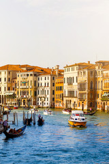 Fototapeta na wymiar View of the Grand Canal with gondolas and colorful facades of old medieval houses from the Rialto Bridge in Venice, Italy. Venice is a popular tourist destination of Europe.