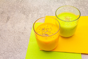 Organic cucumber and carrot smoothies with sesame and chia seeds. Healthy diet concept. On a stone background, copy space.