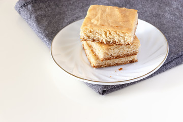 Stack of square pieces lemon shortcrust cake white background. Selective focus.