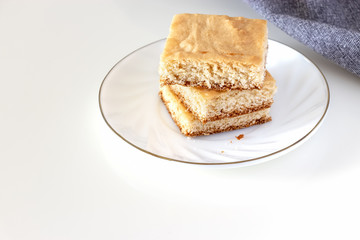 Stack of square pieces lemon shortcrust cake white background. Selective focus.