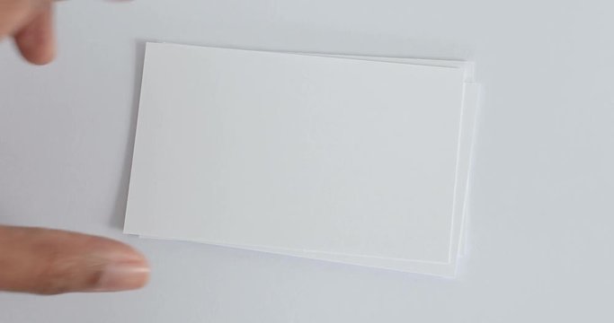 hand taking out one by one of 5 mockup empty white paper card for adding word on paper of any message concept , top view or overhead shot
