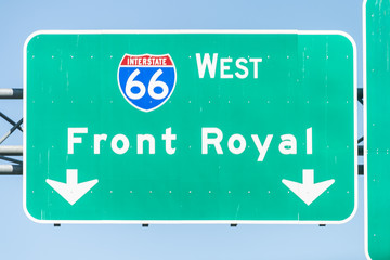 Green road sign to Front Royal city town and interstate highway 66 West in state of Virginia