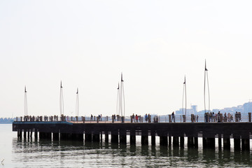 Fototapeta premium People on a wooden pier on the boulevard in Baku. Wooden pier in Baku.