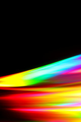 Beams of light refracting and creating a rainbow spectrum of colours against a black background