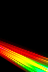 Beams of light refracting and creating a rainbow spectrum of colours against a black background