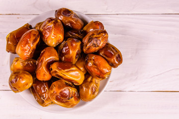 Date fruits on the white wooden table. Top view