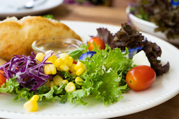 Salad side dish on a white plate on a wooden table