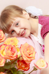 Obraz na płótnie Canvas Little girl with a bouquet of tea roses.
