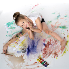 Obraz na płótnie Canvas A little girl paints with paint and brush.