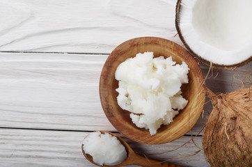 Flat lay background of coconut shell hard oil in wooden bowl on white wooden table