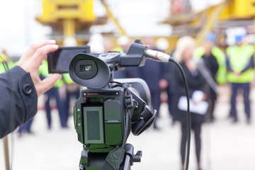 News conference. Filming media event with a video camera.