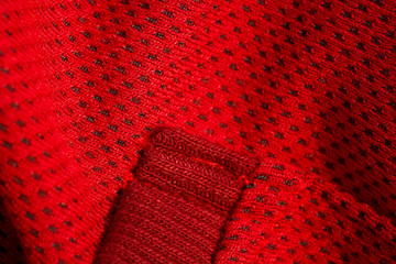 red sportswear closeup top view. seam and juncture. breathable knitwear. clothing details macro