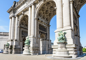 Obraz premium Low angle view of the eastern side of the arcade du Cinquantenaire, the triumphal arch erected in 1905 by king Leopold II in the Cinquantenaire park in Brussels, Belgium, against blue sky.