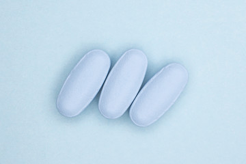 Group of three whole blue medical drug flatlay on sky blue background