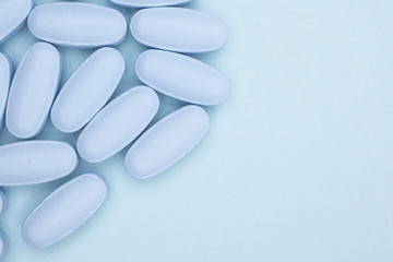 Lot of whole blue medical drug with copyspace flatlay on sky blue background