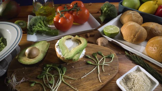 Healthy food. Healthy assortment of vegetables and fruits with legumes: sandwich with avocado and sesame, sprouted grains, fresh bread, lemon, tomatoes, olive oil.